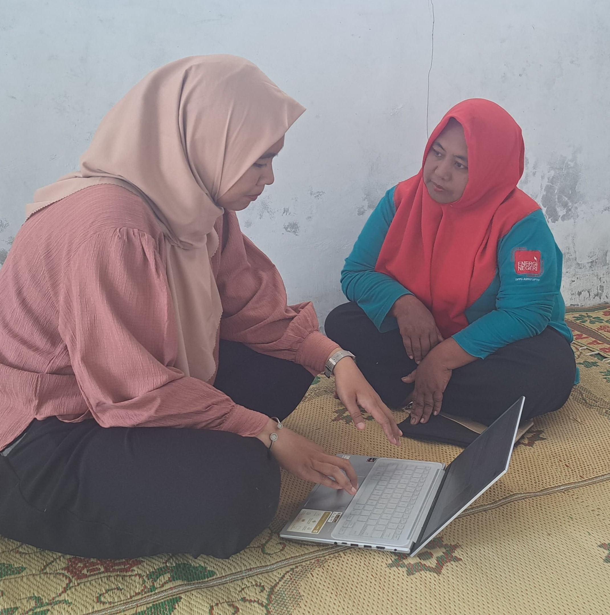 Two women sitting and talking in front of a computer