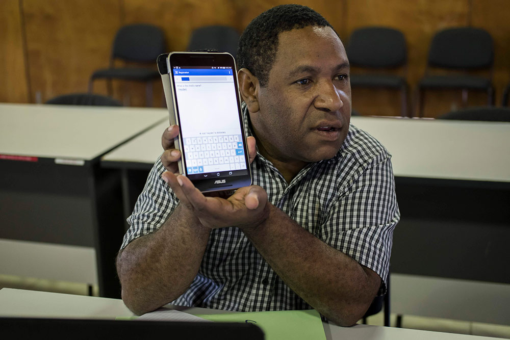 A NARI staff member holds a tablet during a Commcare training delivered by AgImpact at the NARI research station in Leh, in Eastern Highlands Province of Papua New Guinea.